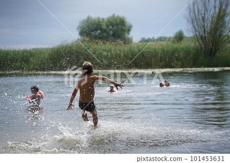 Young boy jumping into the lake. 101453631