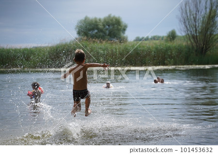 Young boys jumping into the lake. Young boys jumping into the lake. 101453632