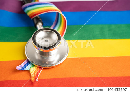 Black stethoscope on rainbow flag background, symbol of LGBT pride month celebrate annual in June social, symbol of gay, lesbian, bisexual, transgender, human rights and peace. 101453797