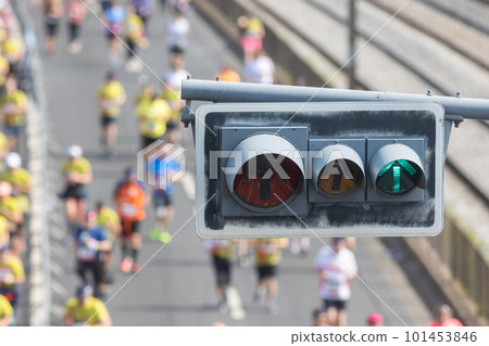 Traffic light in the foreground - people running a half marathon on the bridge Traffic light in the foreground - people running a half marathon on the bridge 101453846