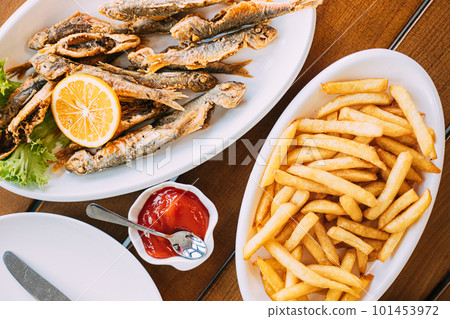 french fries and grilled fishes. fish and chips. Dish with Mullet Fish With orange. Fried fry small fishes 101453972