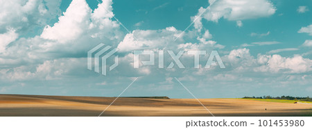 Tractor Plowing Field In Spring Season Sunny Day. Bright Clouds On Background. Countryside Rural Field Landscape. Agricultural Concept Tractor Plowing Field In Spring Season Sunny Day. Bright Clouds On Background. Countryside Rural Field Landscape. Agricultural Concept 101453980