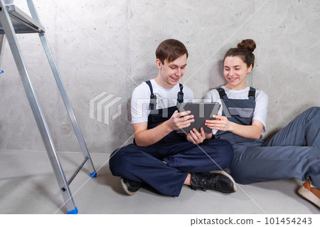 Couple in new home during repair works discussing about home design project looking repair plan on tablet. Happy family choosing new decorations and design. Home renovation DIY renew makeover concept Couple in new home during repair works discussing about home design project looking repair plan on tablet. Happy family choosing new decorations and design. Home renovation DIY renew makeover concept 101454243