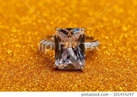 Will you marry me. Wedding ring on golden glitter background. Engagement marriage proposal wedding concept. St. Valentine's Day postcard. Banner on valentines day. Copy space Will you marry me. Wedding ring on golden glitter background. Engagement marriage proposal wedding concept. St. Valentine's Day postcard. Banner on valentines day. Copy space 101454247