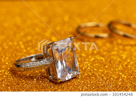 Will you marry me. Engagement ring and two wedding rings on golden glitter background. Engagement marriage proposal wedding concept. St. Valentine's Day postcard. Banner on valentines day. Copy space Will you marry me. Engagement ring and two wedding rings on golden glitter background. Engagement marriage proposal wedding concept. St. Valentine's Day postcard. Banner on valentines day. Copy space 101454248