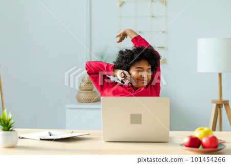 African american girl at home office relaxing stretching hands and body taking break from work on laptop. Joyful young woman freelancer businesswoman happy after work done satisfied by good result 101454266