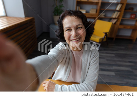 Happy middle aged senior woman talk on video call with friends family. Laughing mature old senior grandmother having fun speaking with grown up children online. Headshot portrait selfie webcamera view Happy middle aged senior woman talk on video call with friends family. Laughing mature old senior grandmother having fun speaking with grown up children online. Headshot portrait selfie webcamera view 101454461