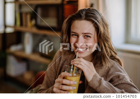 Young woman sitting on sofa with drink. Young woman sitting on sofa with drink. 101454703