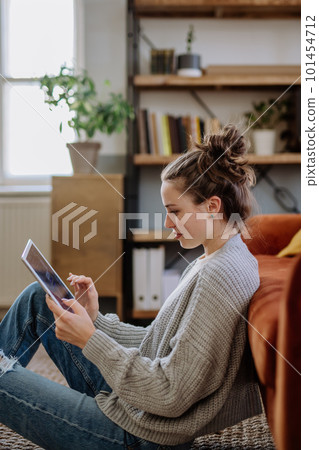 Young woman with digital tablet resting in her apartment. Young woman with digital tablet resting in her apartment. 101454712