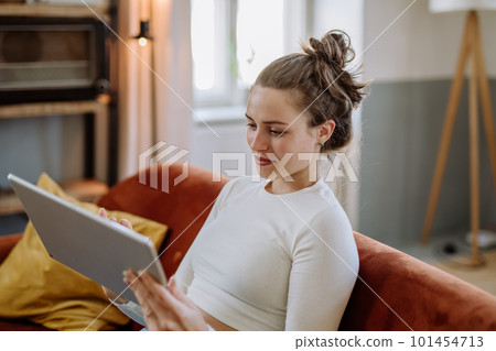 Young woman with digital tablet resting in her apartment. Young woman with digital tablet resting in her apartment. 101454713