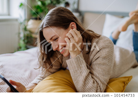 Young woman scrolling her smartphone in the apartment. Young woman scrolling her smartphone in the apartment. 101454733