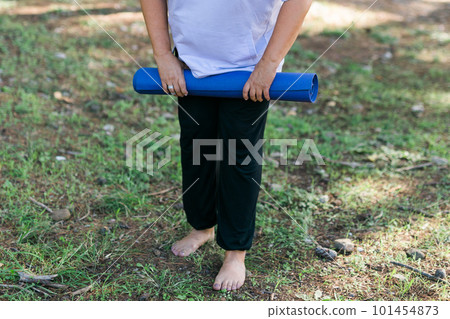 Portrait of mature elderly woman with grey hair dreadlocks going to workout in park and standing with mat for exercises against sea Portrait of mature elderly woman with grey hair dreadlocks going to workout in park and standing with mat for exercises against sea 101454873