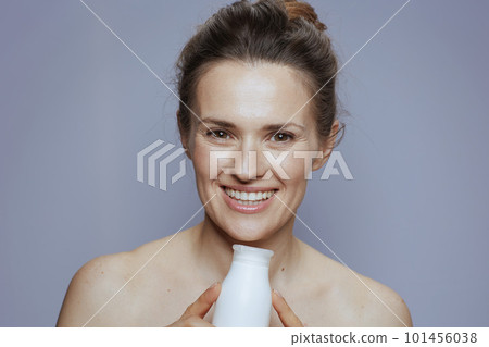 smiling modern 40 years old woman with cosmetic cream jar 101456038