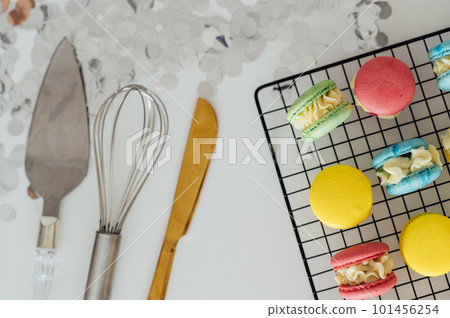 traditional french colorful macarons in a rows on a metal mesh 101456254