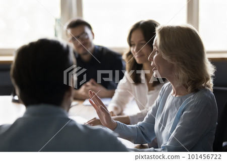 Positive senior business woman speaking at corporate meeting Positive senior business woman speaking at corporate meeting 101456722