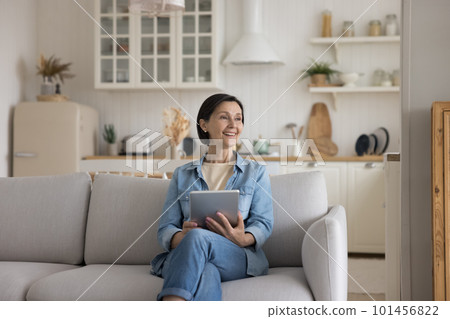 Cheerful pensive mature business owner woman sitting on couch Cheerful pensive mature business owner woman sitting on couch 101456822