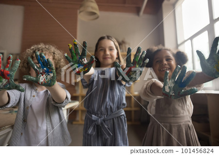Happy joyful art school little pupils showing painted colorful hands Happy joyful art school little pupils showing painted colorful hands 101456824