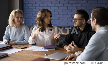 Engaged different aged business team discussing work project 101456848