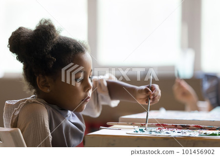 Serious artistic school African American pupil girl painting on canvas Serious artistic school African American pupil girl painting on canvas 101456902