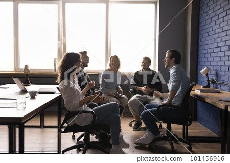 Cheerful diverse team sitting on chairs in circle, brainstorming Cheerful diverse team sitting on chairs in circle, brainstorming 101456916