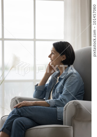 Happy dreamy pretty mature woman relaxing in armchair at home Happy dreamy pretty mature woman relaxing in armchair at home 101457060