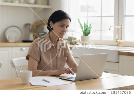 Focused senior freelance professional woman working from home Focused senior freelance professional woman working from home 101457086