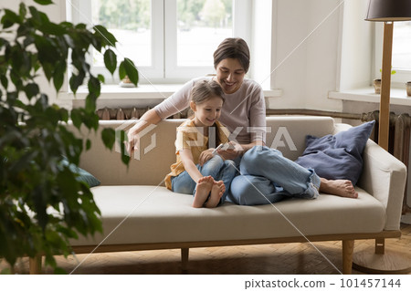 Happy positive mom teaching kid to use online learning app 101457144