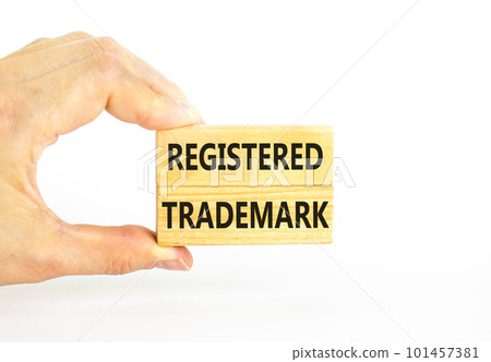 Registered trademark symbol. Concept word Registered trademark on wooden blocks. Beautiful white table white background. Businessman hand. Business and registered trademark concept. Copy space. 101457381