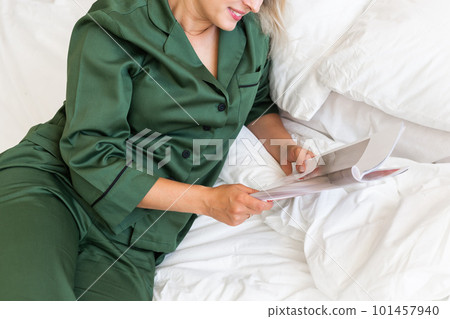 Close up woman wears pajama reads magazine in living room. Homewear, sleepwear, shopping and sale 101457940