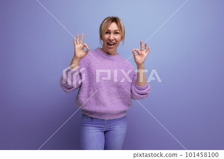 portrait of energetic yawning pleasant blond woman in lavender sweater on purple background with portrait of energetic yawning pleasant blond woman in lavender sweater on purple background with 101458100