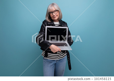 mature old woman with gray hair does a great job with laptop technique with a mockup on a bright mature old woman with gray hair does a great job with laptop technique with a mockup on a bright 101458115