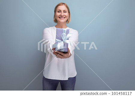 happy blonde middle aged woman received a gift on studio background 101458117