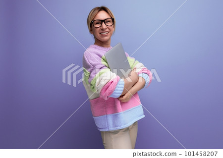 successful blond woman freelancer with a laptop in her hands rejoices with happiness on a purple 101458207