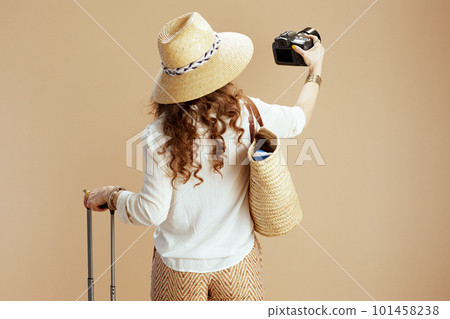 Seen from behind woman in blouse and shorts on beige Seen from behind woman in blouse and shorts on beige 101458238