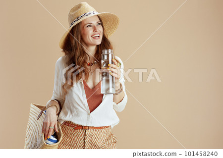 happy stylish female in blouse and shorts isolated on beige 101458240