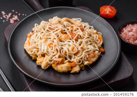 Delicious noodles with chicken and vegetables or udon on a black ceramic plate Delicious noodles with chicken and vegetables or udon on a black ceramic plate 101459176
