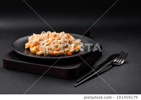 Delicious noodles with chicken and vegetables or udon on a black ceramic plate 101459179