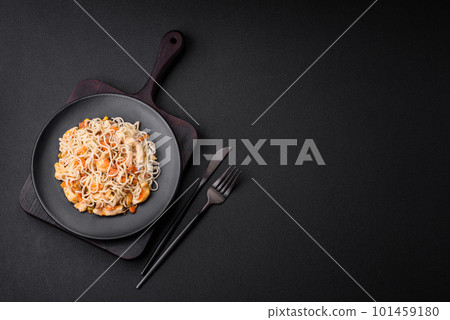 Delicious noodles with chicken and vegetables or udon on a black ceramic plate 101459180