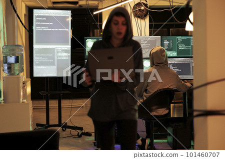 Hackers team using computers to plant virus and hack network system, trying to steal sensitive information from government server at night. Two spies hacking computer, identity theft. 101460707