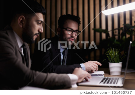 Side view of computer systems analysts using charts on computer monitors while working in office Side view of computer systems analysts using charts on computer monitors while working in office 101460727