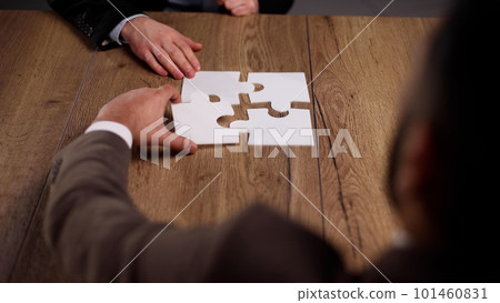 Group of business people putting together a puzzle on a table 101460831