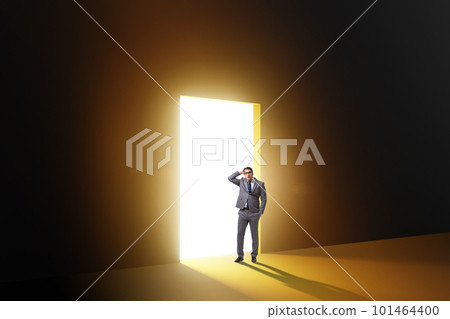 Businessman entering backlit door in escape concept Businessman entering backlit door in escape concept 101464400