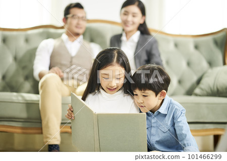 two asian children reading book together two asian children reading book together 101466299