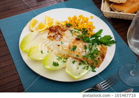 Tasty fried codfish served with endive, greens and corn 101467718