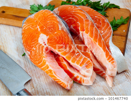 Raw salmon fillet on wooden table 101467740