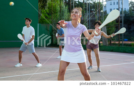 Woman playing Basque pelota on outdoor pelota court 101467822