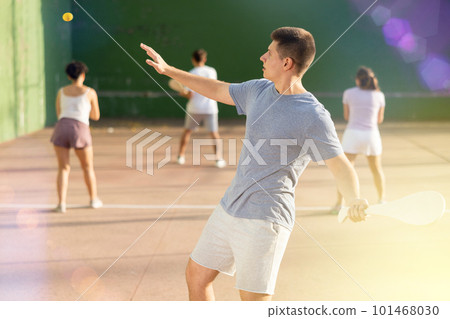 Young male pelota player hitting ball with racket Young male pelota player hitting ball with racket 101468030