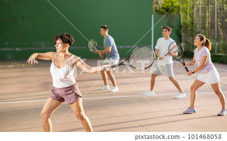 Woman pelota player hitting ball with racket 101468058