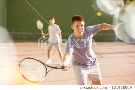 Sports active man during friendly doubles couple match. Two men playing frontenis together outdoor Sports active man during friendly doubles couple match. Two men playing frontenis together outdoor 101468069