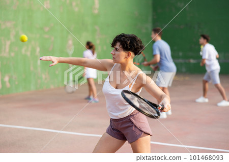 Expressive resolved fit girl playing frontenis ball friendly match on court 101468093